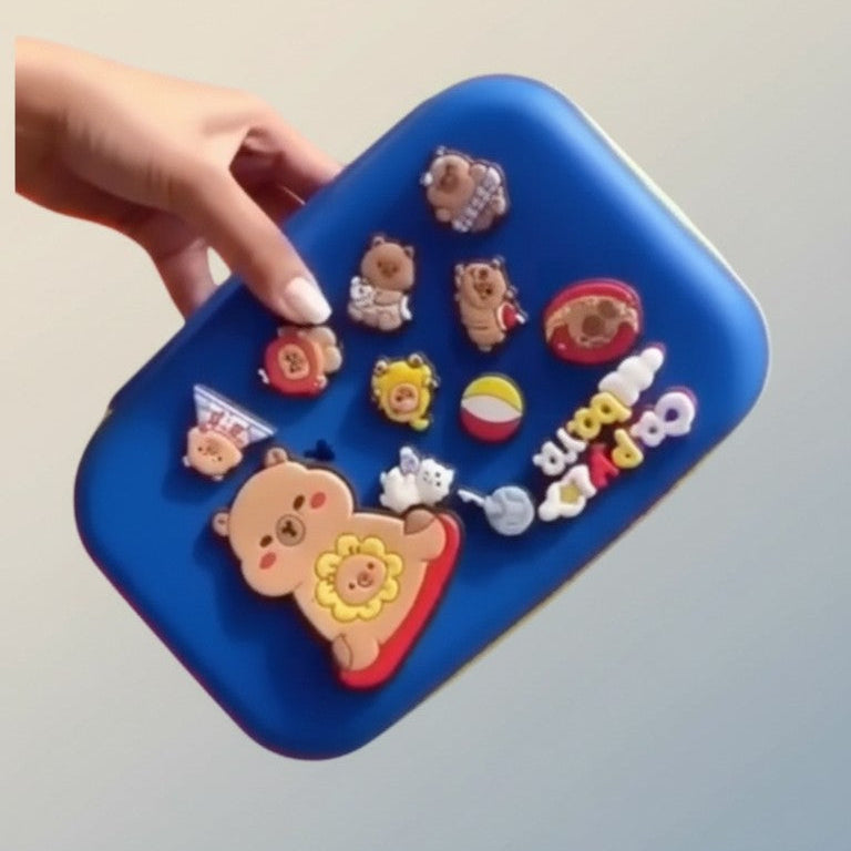 Blue case with colorful animal-shaped stickers held by a hand against a light gray background