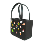 Mango Muffins black waterproof PVC tote bag decorated with colorful Jibbitz charms like an octopus and beer mug.
