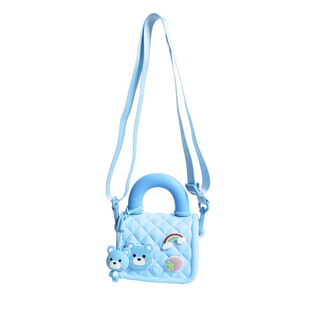 Mango Muffins light blue quilted sling bag with bear, rainbow, and strawberry charms. Adjustable strap.