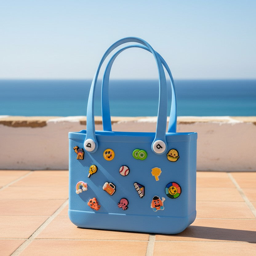 Mango Muffins blue waterproof PVC tote bag with colorful charms, perfect for beach or pool days.