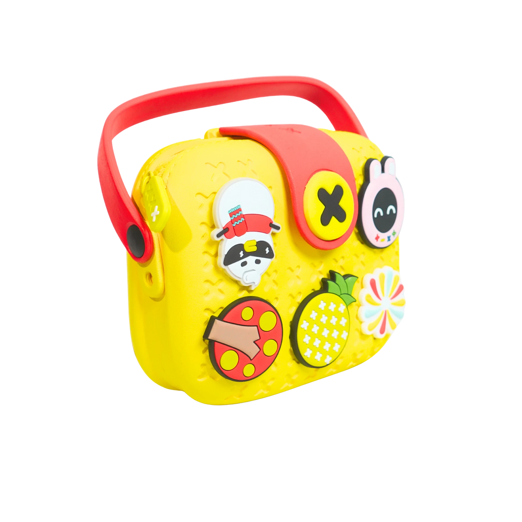 Mango Muffins yellow EVA crossbody sling bag for kids with red handle and customizable charms like a raccoon, pineapple, and ladybug.