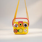 Mango Muffins yellow EVA crossbody sling bag for kids with red handle and yellow strap, featuring customizable charms.