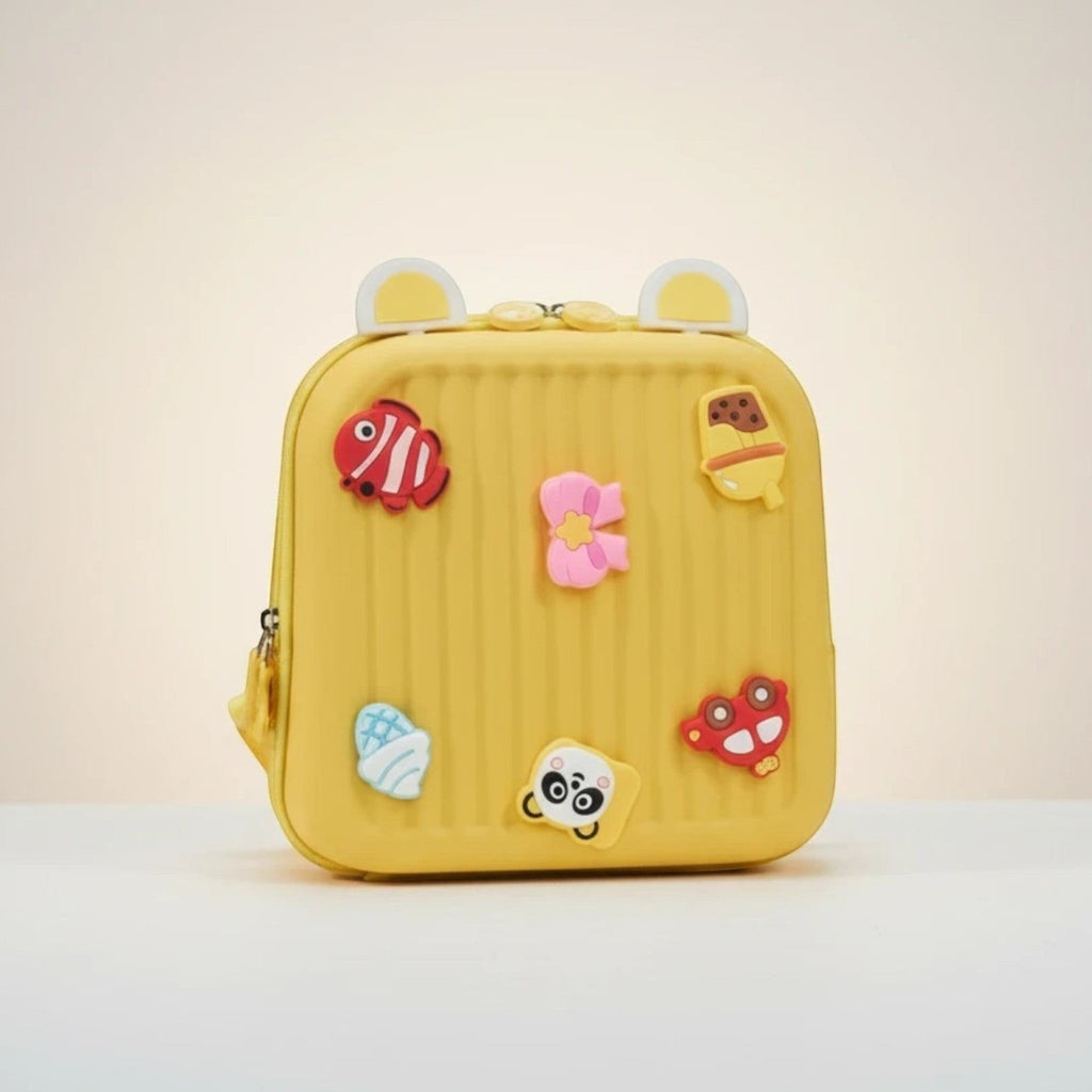 Mango Muffins yellow hard shell backpack with 3D charms: fish, ice cream, flower, acorn, panda, and car.